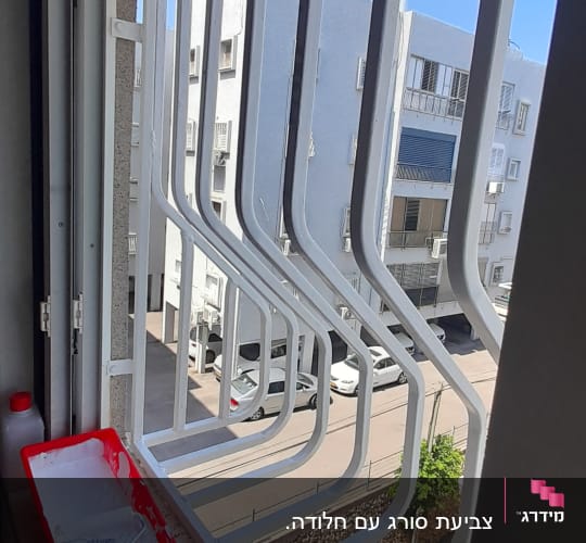 מגש צבע אדום עם מברשת על אדן חלון